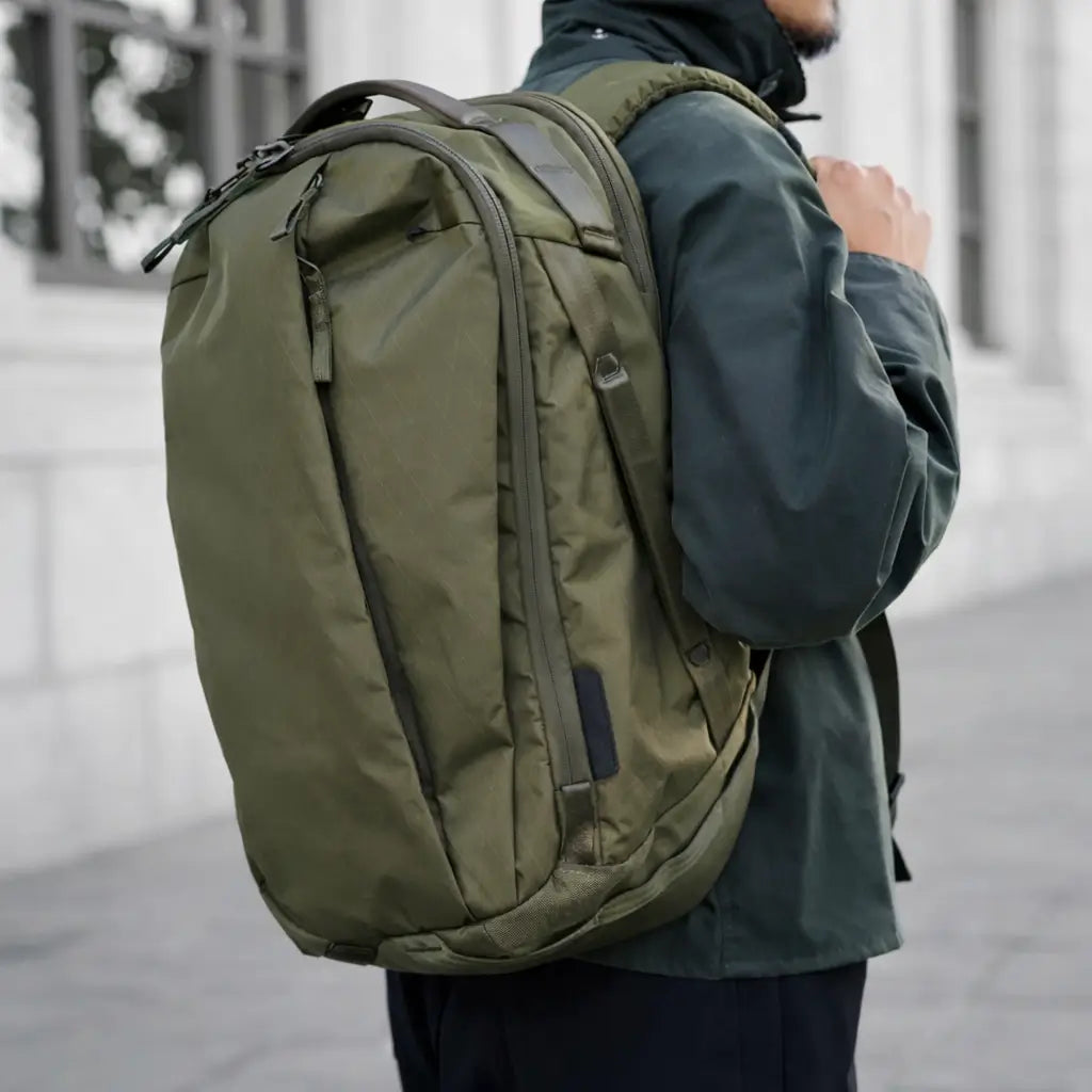 Person trägt olivgrünen Premium-Reiserucksack im urbanen Alltag